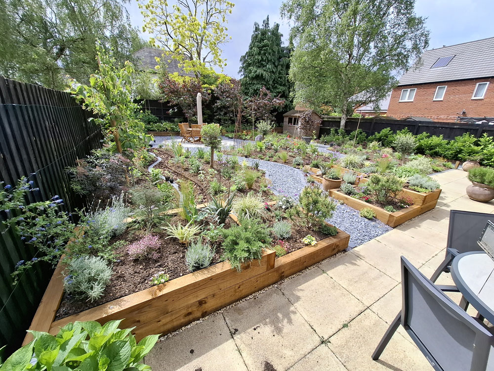 Large Makeover with winding slate paths and herbaceous borders